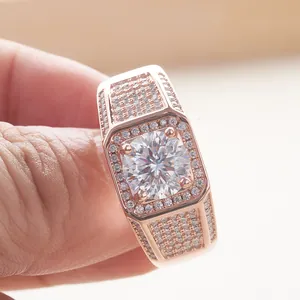 Macro shot of luxury rose gold ring featuring a large moissanite center stone held between fingers