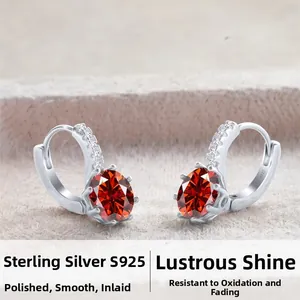 Macro view of S925 sterling silver earrings with red oval-cut stones and white zircon