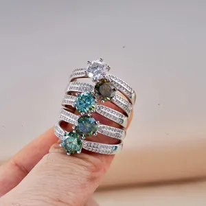 Close-up of stacked sterling silver rings with colorful round moissanite gemstones