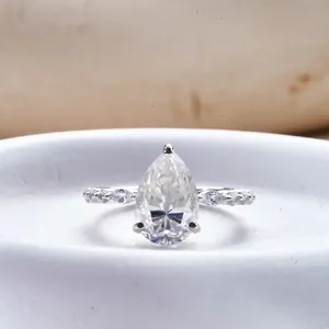 Vista macro de anillo de moissanita de 4 quilates corte pera con micro-pavé en plata