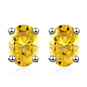 Detalle de pendientes de moissanita amarilla ovalada con engaste de cuatro garras
