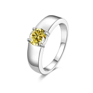 Macro shot of a yellow round-cut moissanite stone in a polished silver four-prong setting