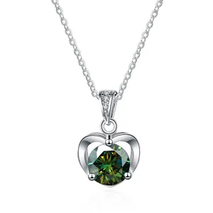 Primer plano del colgante de corazón con gema verde brillante y cadena de plata