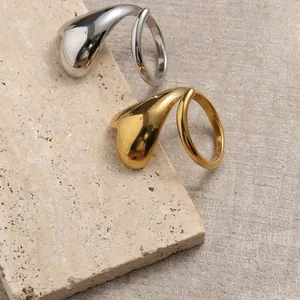 Dettaglio degli anelli a cuore minimalisti in oro e argento su superficie di marmo