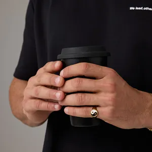Golden Tai Chi Yin Yang stainless steel signet ring for men on model holding a cup