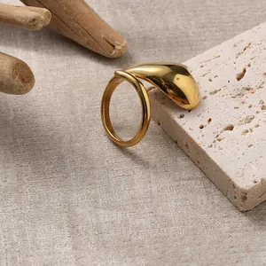 Anello dorato minimalista a cuore esposto su pietra naturale con un design moderno