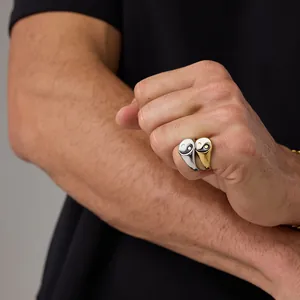 Detail of Tai Chi Yin Yang titanium steel rings in gold and silver finish on male hands