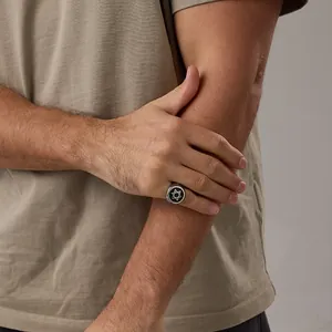 Detailopname van een vintage roestvrijstalen zegelring met zwarte Davidster op model