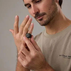 Gros plan d'une bague chevalière noire en acier inoxydable avec gravures de croix pour homme