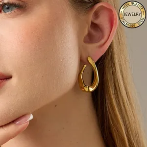 Close-up of irregular gold plated stainless steel twisted hoop earrings on a model