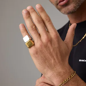 Close-up of minimalist gold and silver square signet rings with matte finish on male model