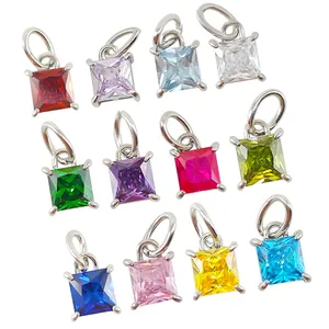 Macro shot of twelve colorful square princess cut zircon pendants in silver claw settings