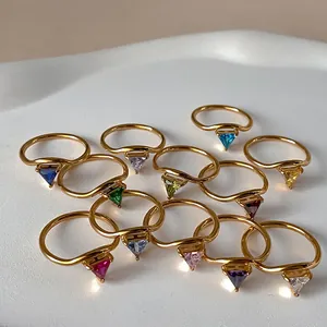 V-shaped 18K gold plated rings with colorful triangular zircons on a white ceramic tray