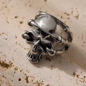 Close-up of gothic silver skull ring with bone textures on natural stone base