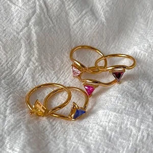 Detailed close-up of five V-shaped 18K gold-plated rings with colorful triangle zircons