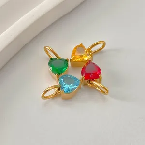 Macro shot of heart-shaped zircon pendants in green, yellow, red, and blue with gold plating