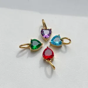 Detailed view of four heart-shaped zircon pendants in purple, green, blue, and red with gold claw settings