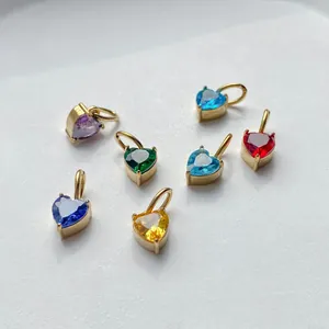 Close-up of seven colorful heart-shaped zircon charms with gold-plated metal settings