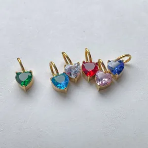 Detail of six heart-shaped colorful zircon charms with gold metal base settings