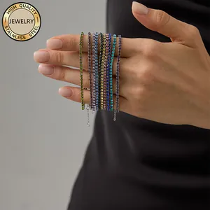 Detail von bunten Tennisarmbändern aus Edelstahl mit leuchtenden Steinen am Handgelenk