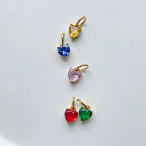 Detail of five heart-shaped zircon pendants in gold frames showing multiple colors
