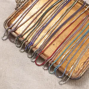 Détail de colliers en zircon coloré disposés sur un plateau doré vintage