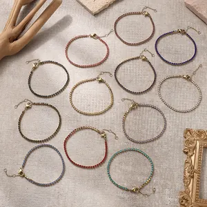 Bunte Zirkonia-Tennisarmbänder in verschiedenen Edelsteinfarben auf beigem Hintergrund