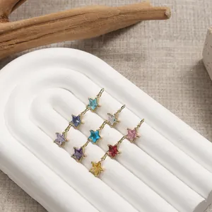 Star-shaped stainless steel crystal pendants in nine colors on a textured stand
