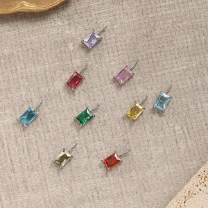 Macro view of colorful rectangular zircon pendants in polished stainless steel settings