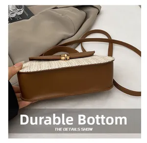 Detail showing the wear-resistant leather base and golden twist lock of the straw bag