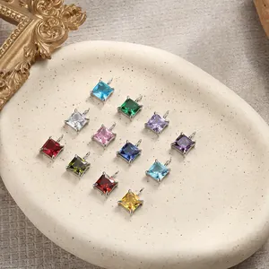 Detail of twelve colorful square-cut gemstone pendants in silver four-prong settings