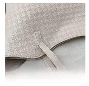 Macro shot of precise stitching and houndstooth texture on cream tote bag