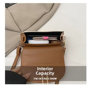 Internal capacity of brown leather saddle bag showing phone, makeup, and daily essentials