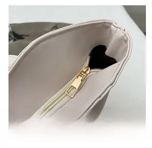 Close-up of smooth gold metal zipper and leather texture on a stylish tote bag