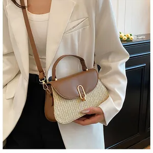 Close-up of the textured straw weave and brown PU leather stitching on the handbag