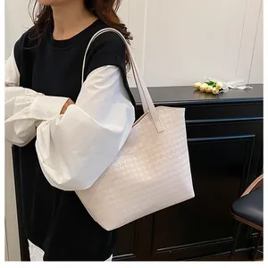 Close-up of cream woven tote bag with houndstooth texture and stylish shoulder strap