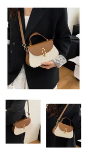 Detail view of woven straw tote with brown leather trim and gold magnetic buckle