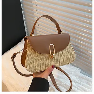 Detail of hand-woven straw bag with premium brown leather trim and golden metal lock