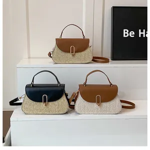 Detailed macro of woven straw bags with premium leather flaps and gold oval metal locks