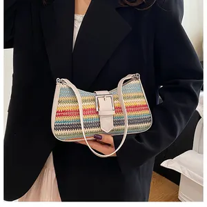 Détail d'un sac en paille tissée arc-en-ciel avec garniture en cuir et boucle en métal
