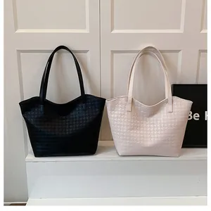 Detail of black and beige houndstooth tote bags with smooth curved edges on white steps