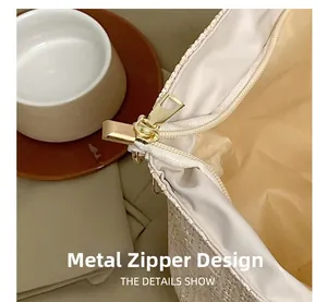 Gros plan du zip doré et de la texture tissée beige sur un grand sac en paille