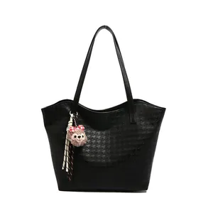 Large black houndstooth pattern tote bag with shoulder straps and a plush bear charm
