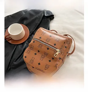 Detail of a brown bear-print backpack with diamond patterns and zip pocket detail