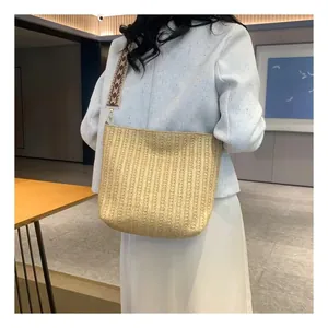 Détail d'un sac cabas en paille tressée avec une bandoulière en jacquard ethnique chic