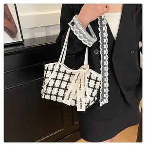Detail einer schwarz-weißen Tweed-Einkaufstasche mit dekorativem bedrucktem Band