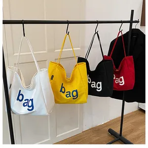 Vue détaillée des sacs cabas en toile blanc, jaune, noir et rouge avec imprimé sac