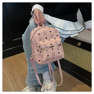 Vue détaillée du mini sac à dos rose avec imprimés ours et texture en similicuir grainé