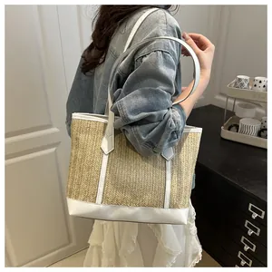 Détail d'un grand sac cabas en paille avec bordure en cuir blanc et anses solides