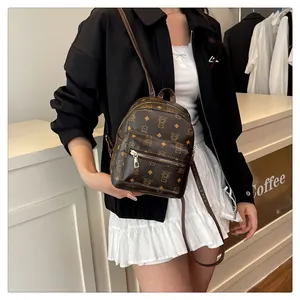 Lifestyle shot of a mini brown faux leather backpack with bear print and golden zippers